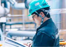 プラント施設内で書類に目を通すエンジニア