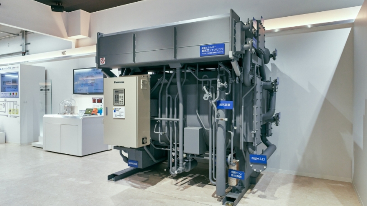 吸収式冷凍機「ナチュラルチラー」の大型展示モデル。多数の配管や制御盤が組み込まれた複雑な構造を外観から俯瞰している様子。