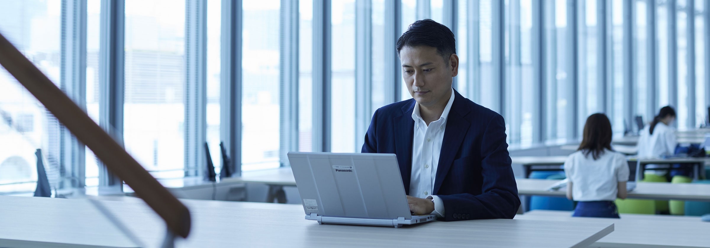 社内フリースペースにてノートパソコンを開いて仕事をする壬生の画像