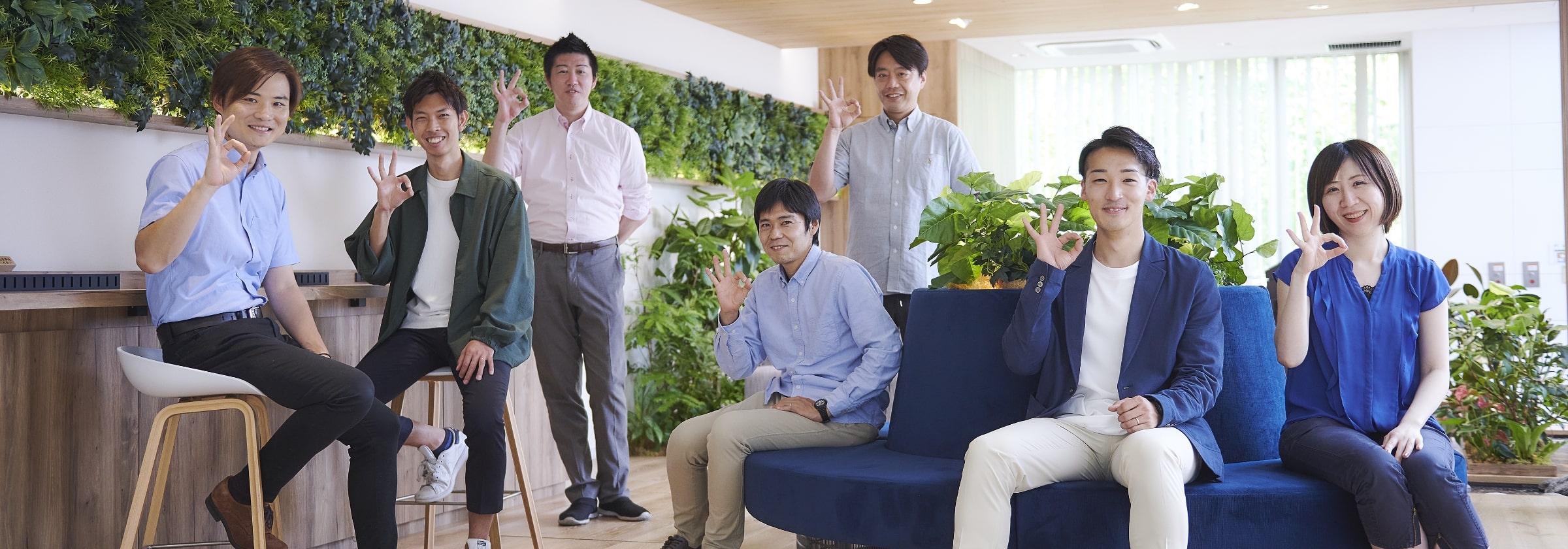 笑顔でOKサインをする男女スタッフの集合画像