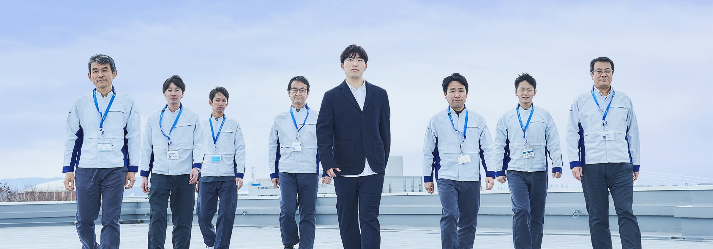 屋上で並び立つ男性スタッフの集合画像