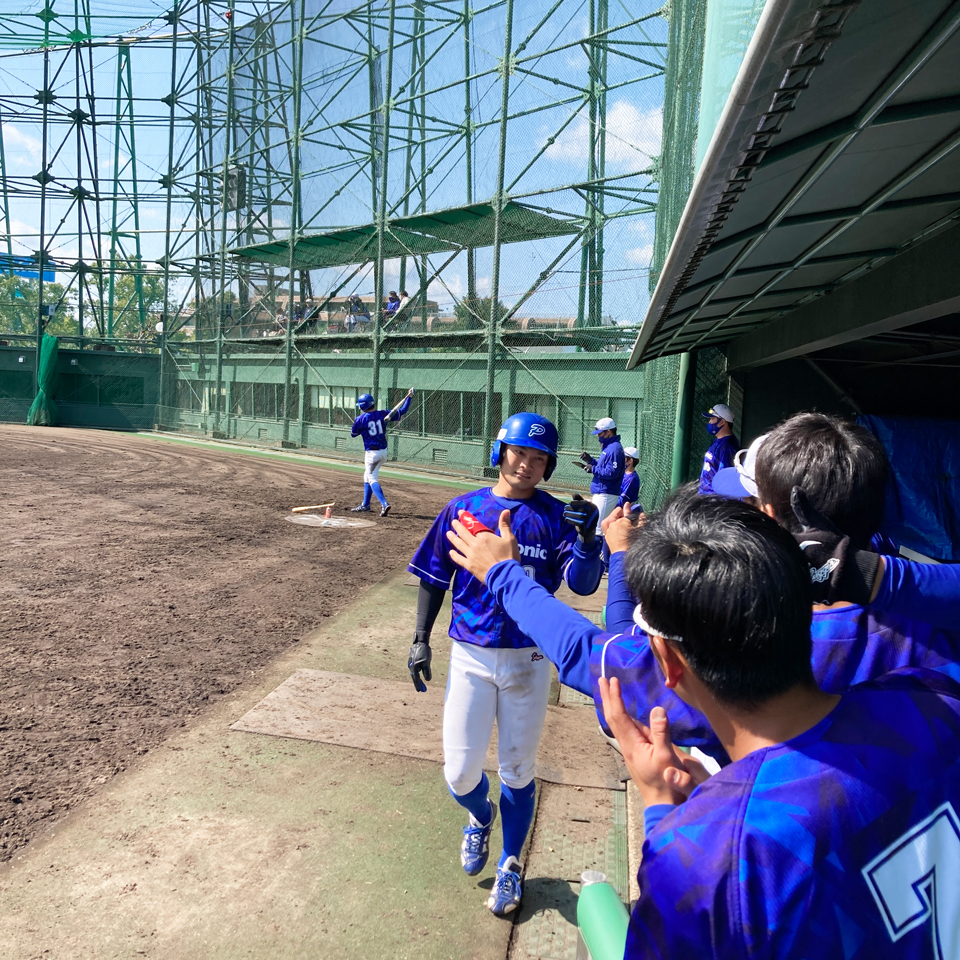 生還したランナーをグータッチで迎え入れるナインたち。