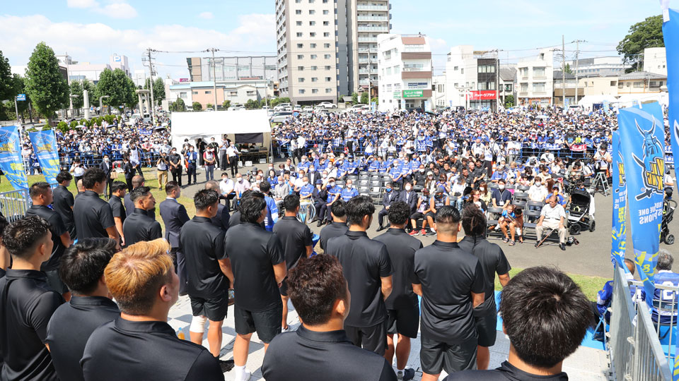 画像:大勢のお客様、チームメンバー、来賓の皆様が集ったコミュニティ広場。ステージ上からの様子。